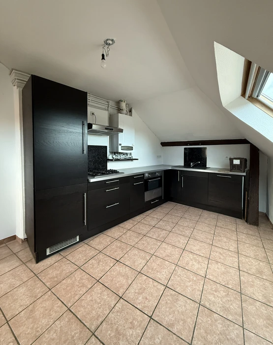 Cuisine moderne en duplex sous combles, avec fenêtre de toit Velux