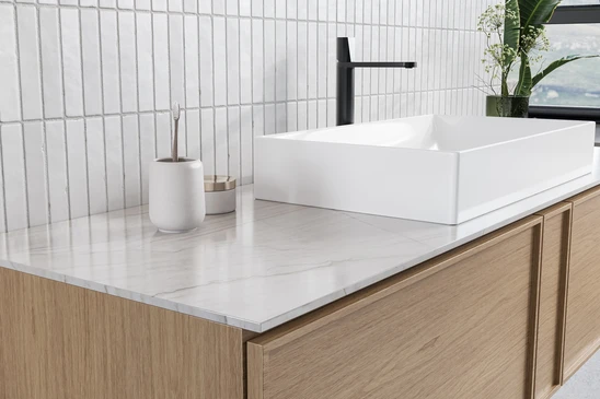 Salle de bain moderne avec double vasque encastr&eacute;e dans plan de travail en pierre naturelle blanche vein&eacute;e