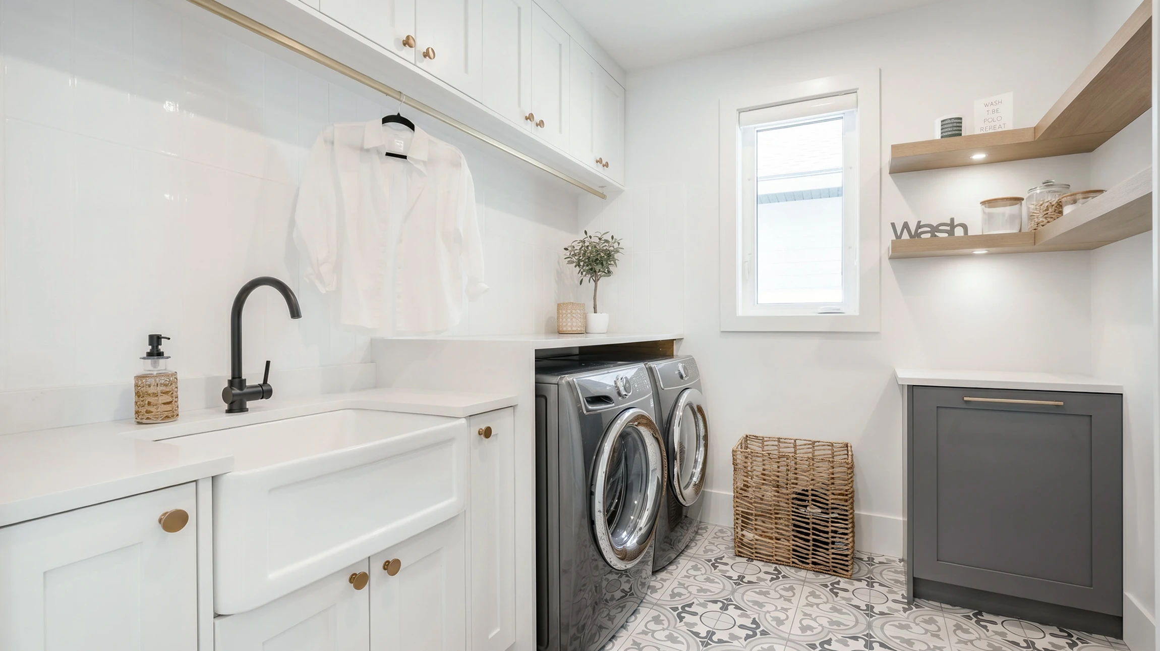 Buanderie moderne avec évier blanc encastré, robinet noir mat, lave-linge et sèche-linge frontaux en inox