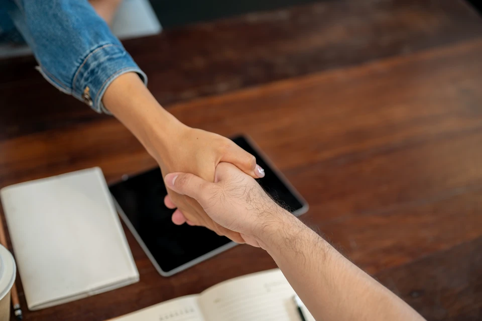 Scène de consultation professionnelle en intérieur moderne avec couple assis sur canapé gris face à conseiller en costume